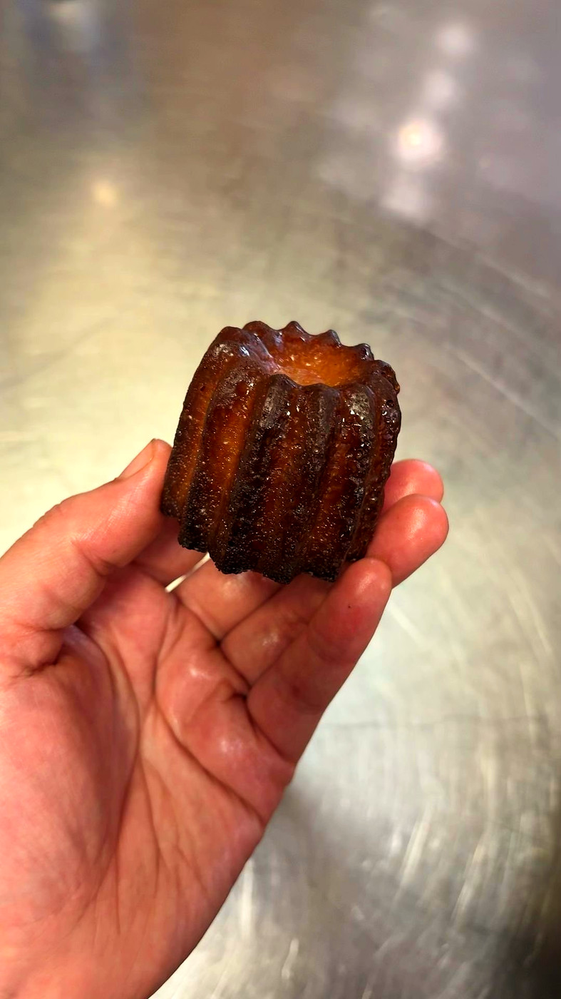 Canelé bordelais tenu dans la main